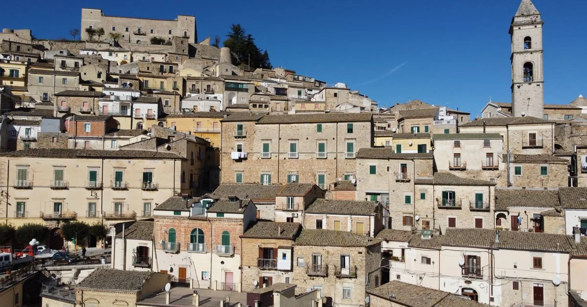 Vue charmante d'une ville italienne perchée sur une colline, à l'architecture intemporelle et sous un ciel d'un bleu limpide.