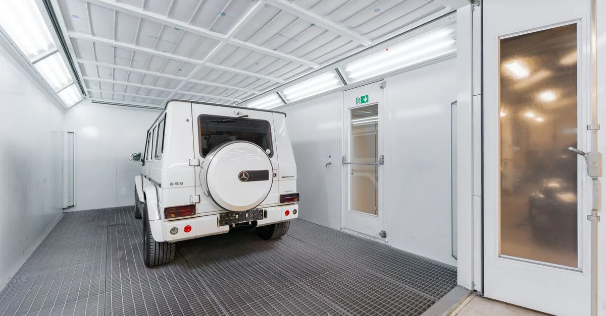 SUV de luxe blanc garé dans un garage automobile lumineux et moderne.